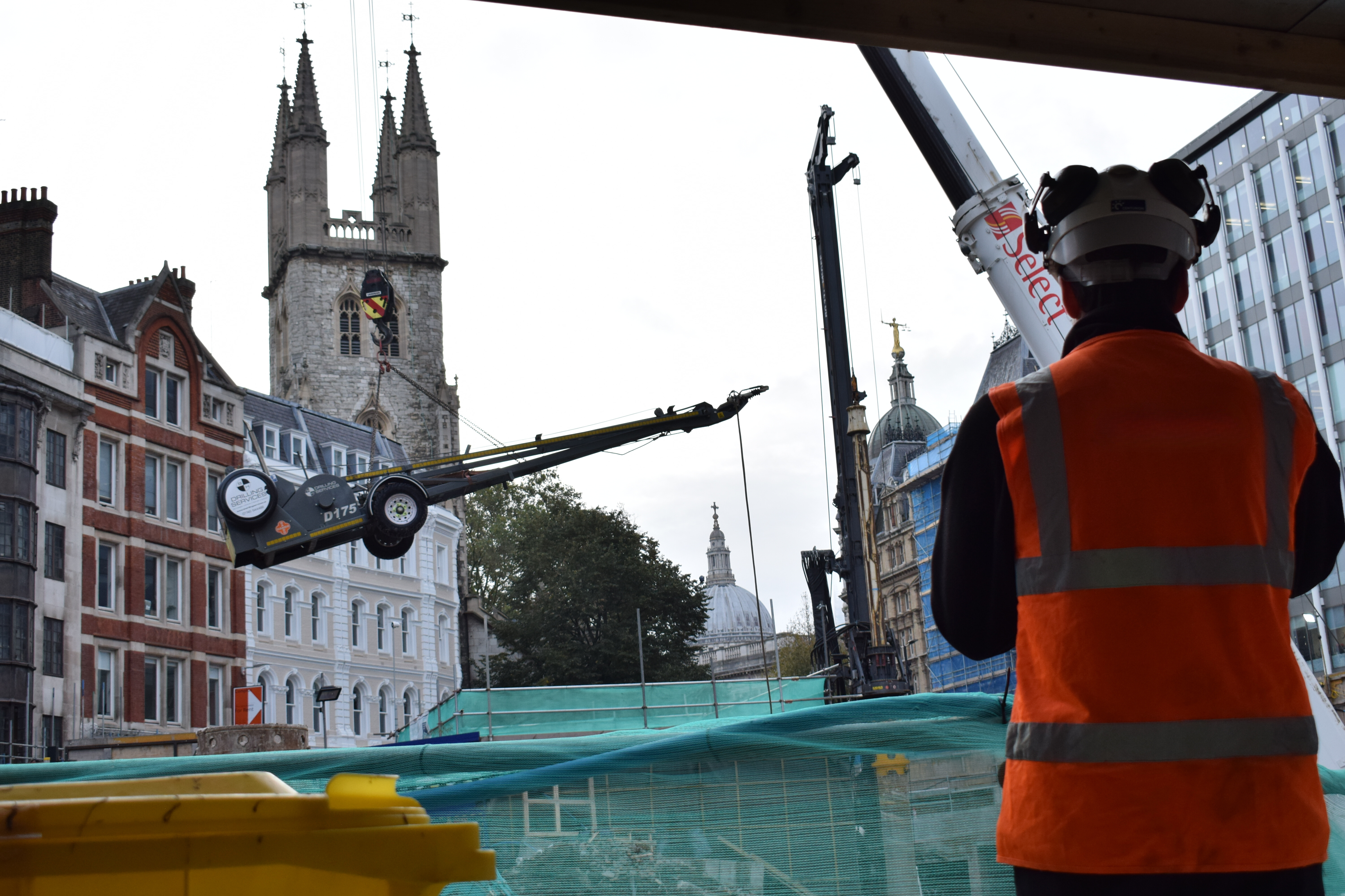 Worker watching a rig being craned into place